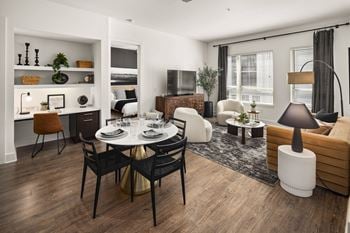 a living room and dining room with a table and chairs